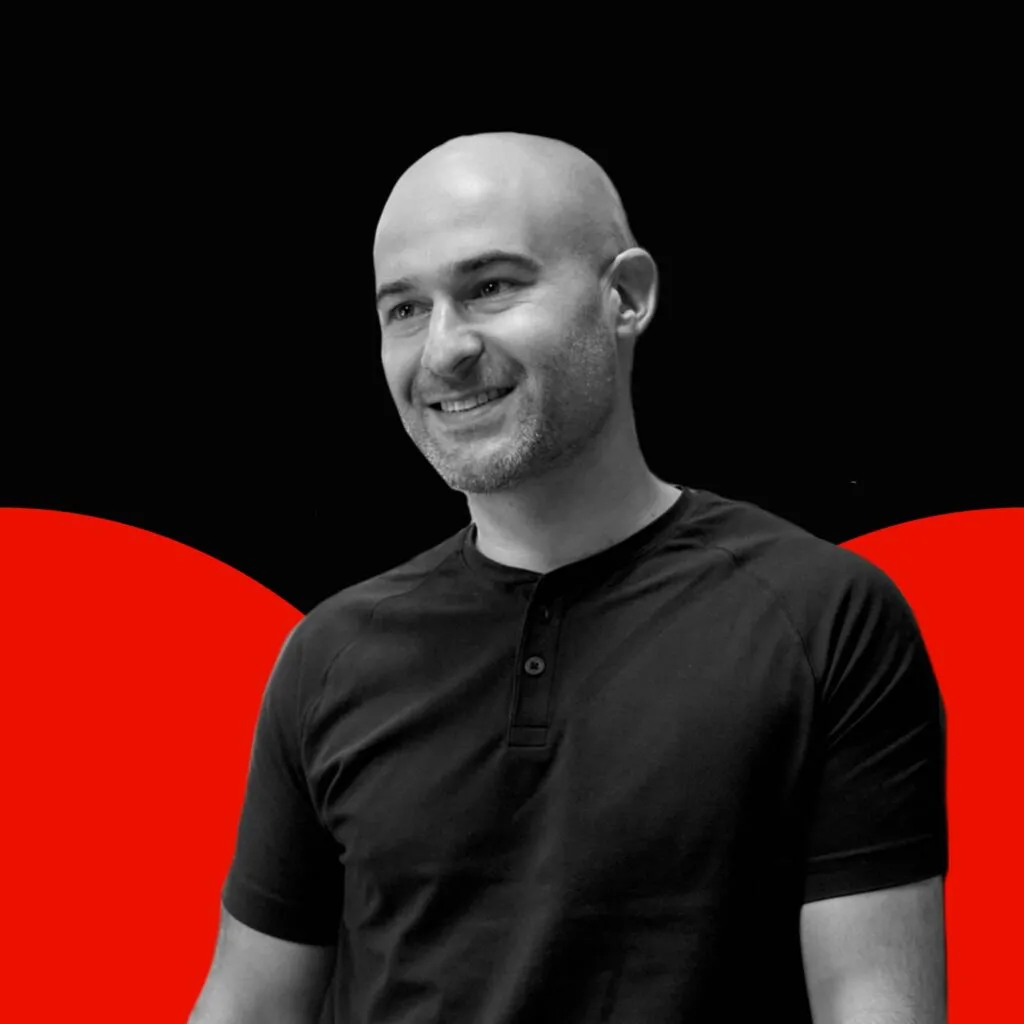 Black and white photo of Justin Handler with red semi circles in the background