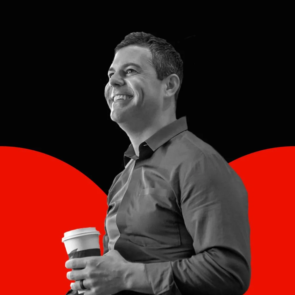 Black and white photo of Keith Scandone with red semi circles in the background